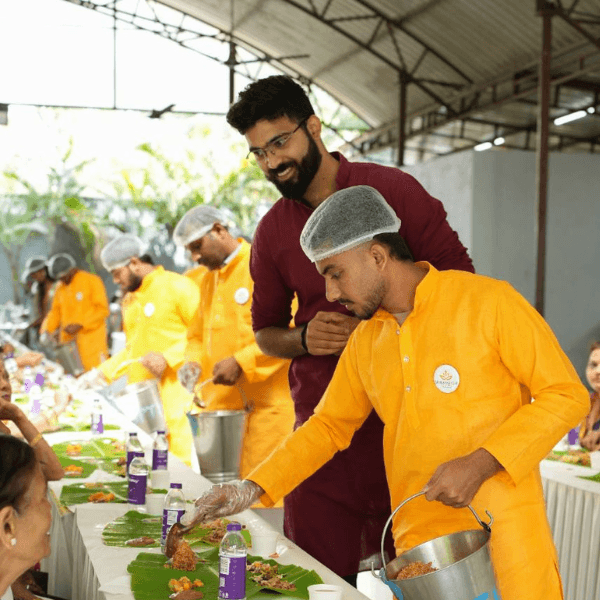 Chaitanya Kini serving guests at a Kamakshi Catering event